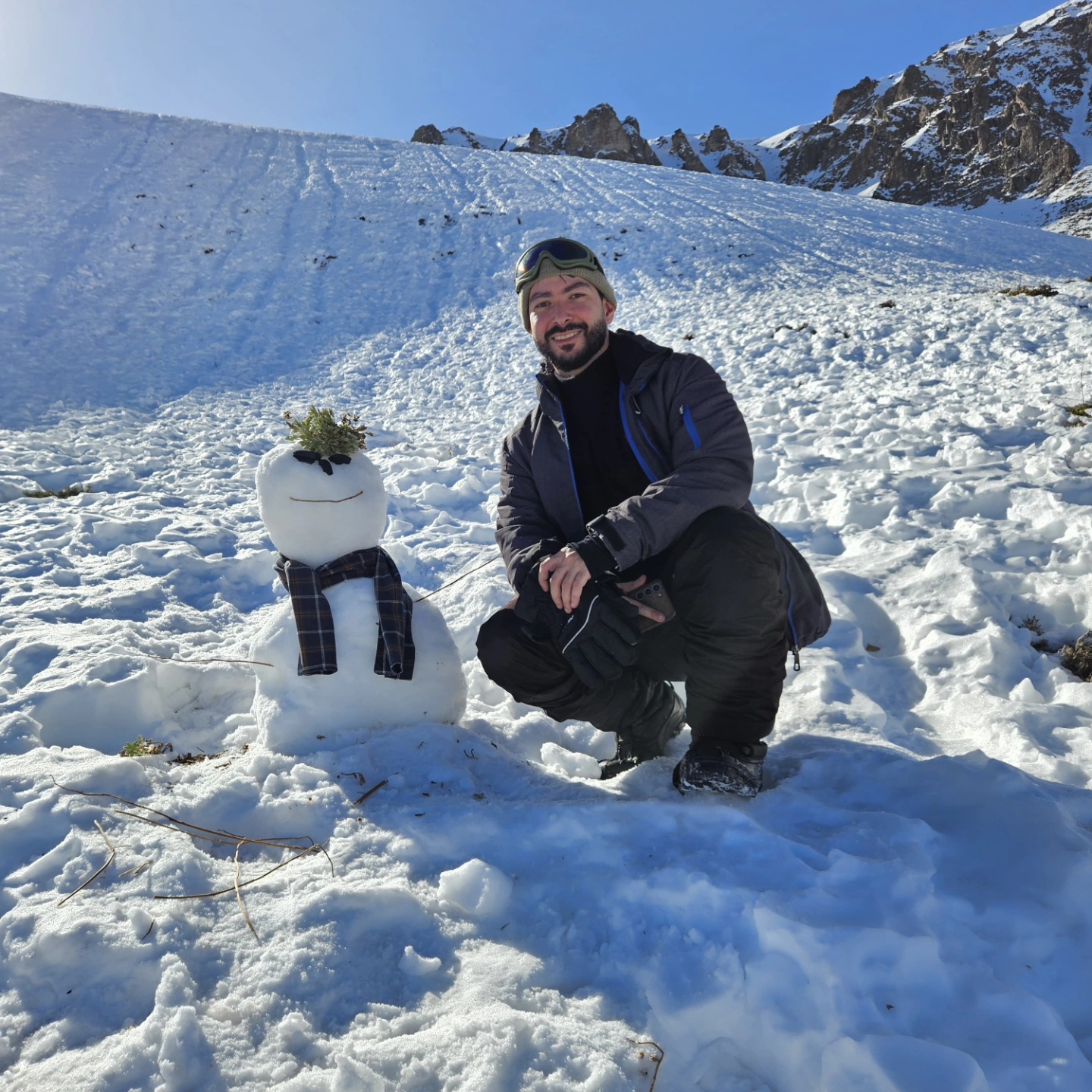 Pedro Fagundes na neve ao lado de um boneco de neve